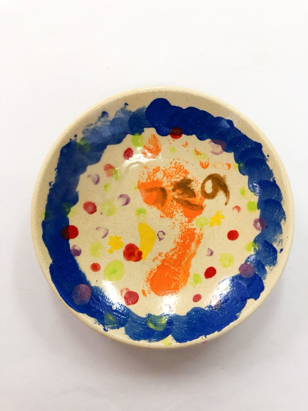 子供が手形と絵の具で仕上げたカラフルな皿